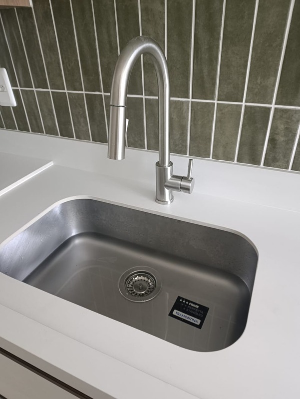 Pia de inox com torneira cromada em bancada clara