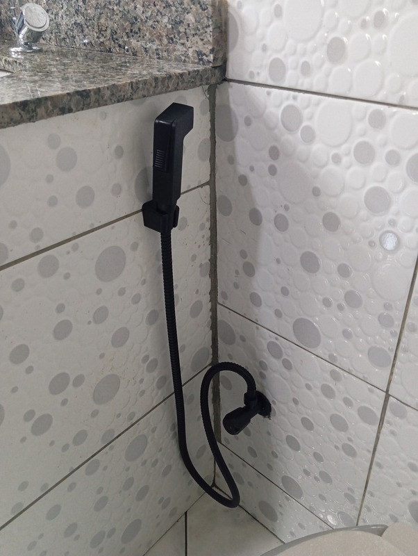 Ducha higiênica preta instalada em banheiro